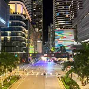 Vibrant city scene in Brickell, Miami Lakes, featuring towering buildings and many people enjoying the street.